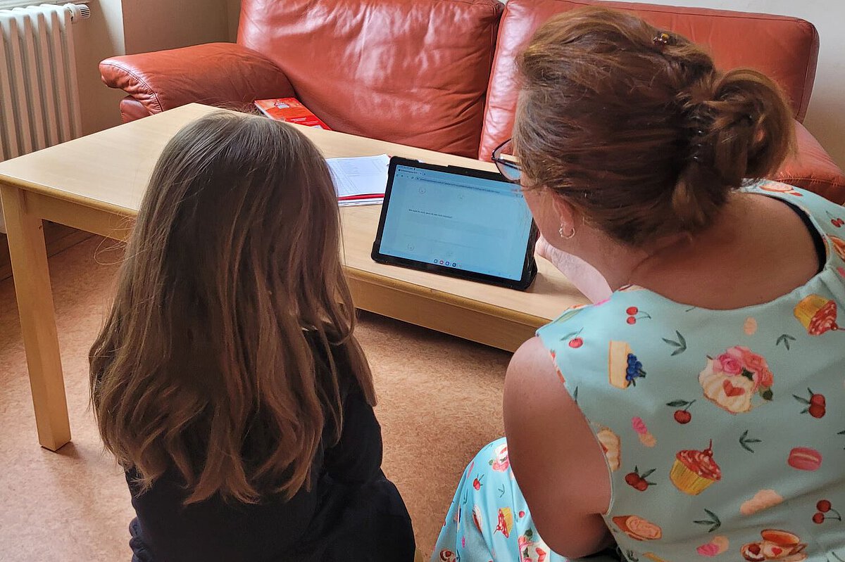 Gemeinsam für Kinder mit digitalen Medien Kita Lowi Pädagogische Fachkraft und Kind arbeiten gemeinsam am Tablet der Kita Lowi