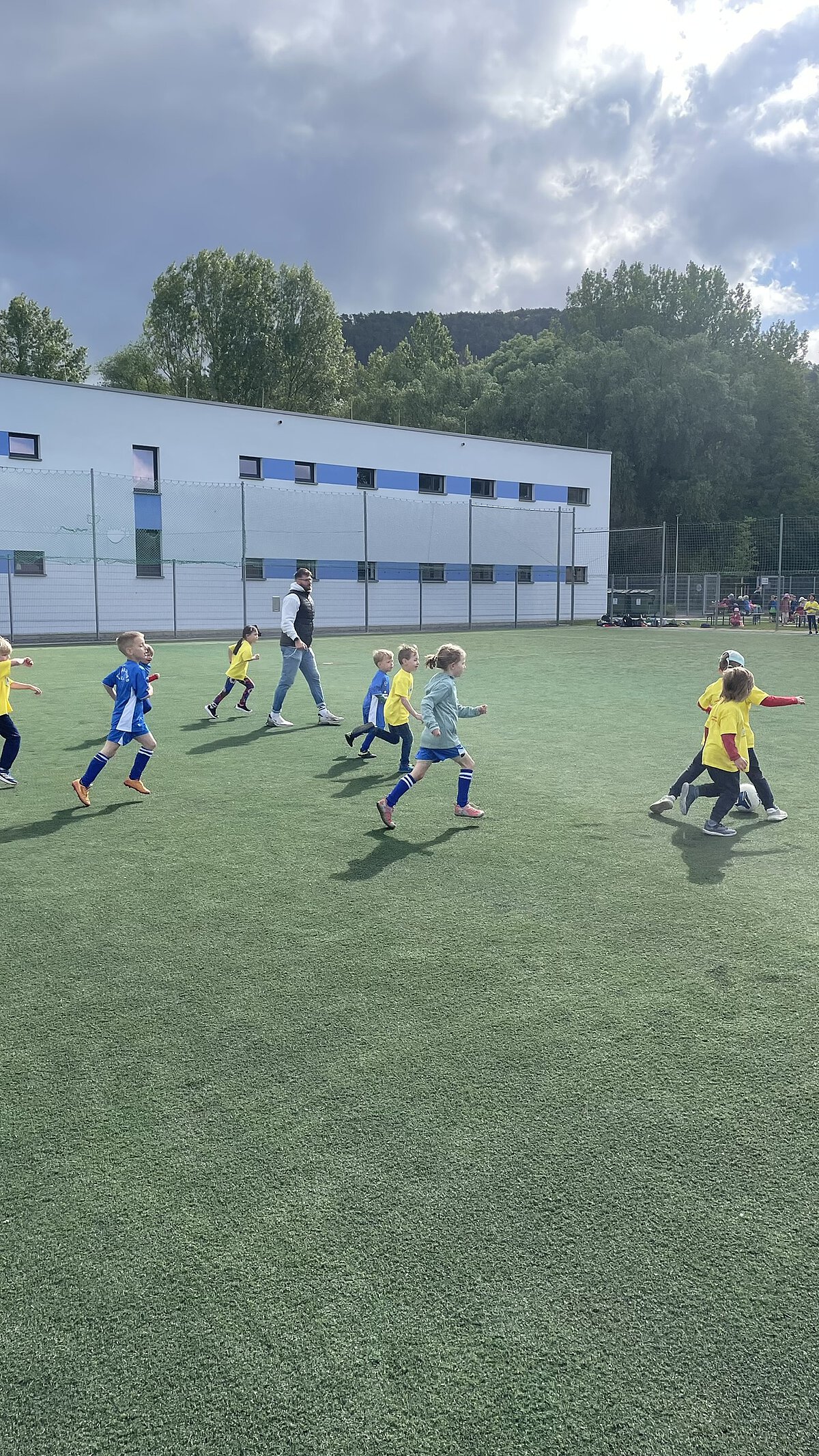 Kinder laufen über das Fußballfeld