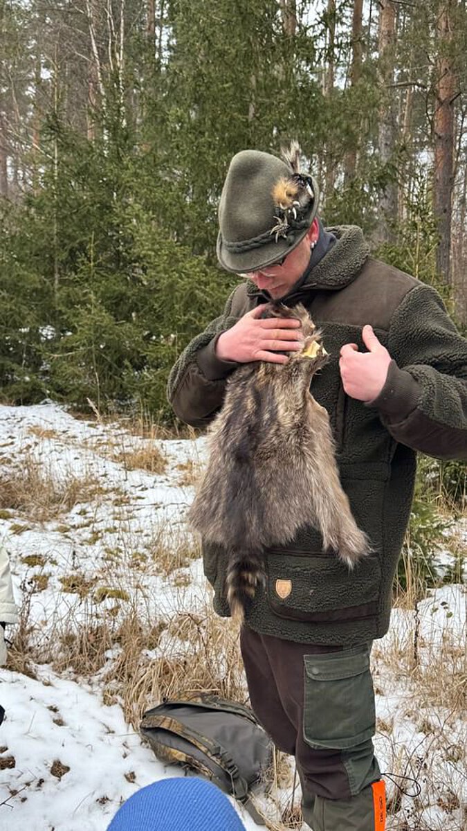 Jäger, der Fuchsfell vor seinen Körper hält