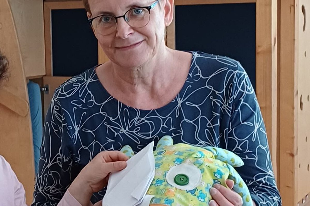 Pädagogische Fachkraft unterstützt Kinder bei einer Gesprächs- und Beteiligungssituation in der Kita Bergfelderweg.