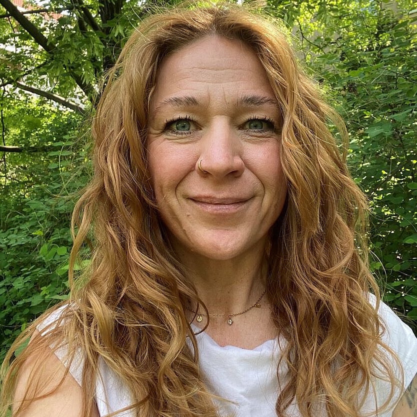 Portraitfoto Einrichtungsleitung Kindertagesstätte Striesener Entdeckerland Ina Helbig vor grünem, natürlichen Hintergrund