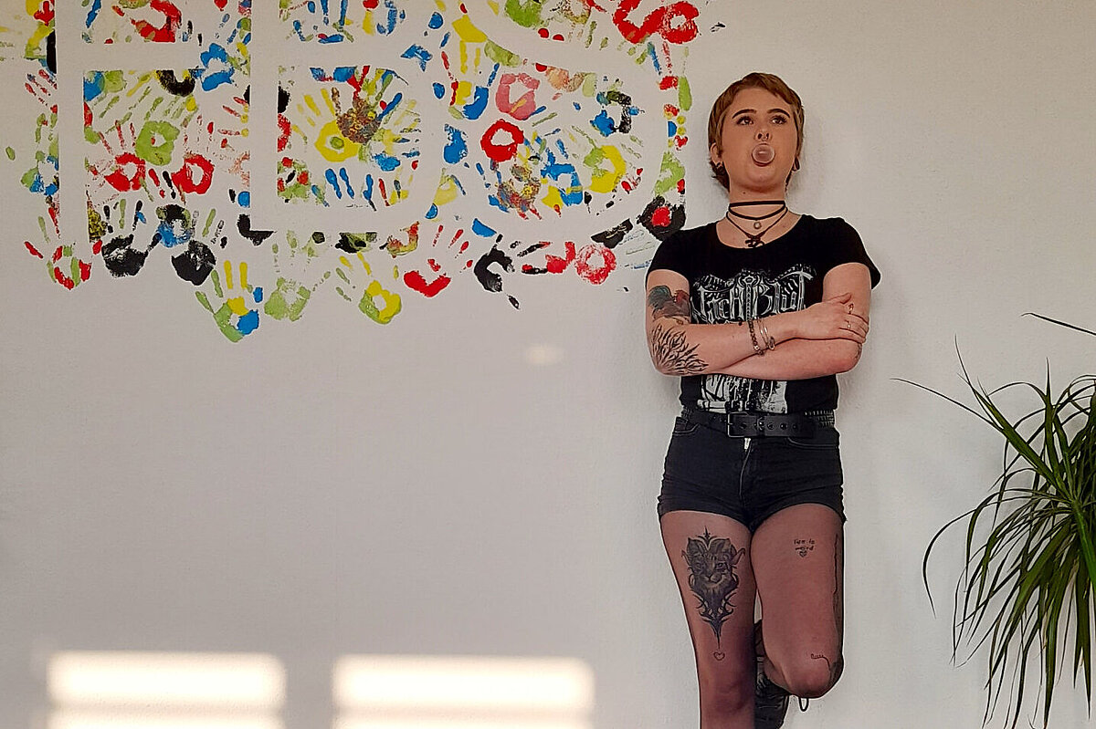 Lena, Auszubildende der FBS Dresden, vor einer Wand mit Handabdrücken
