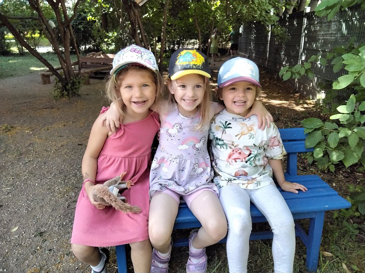 Freundschaft - Glückliche Kinder - Kindergarten Windischholzhausen Drei Freunde sitzen auf der Bank und haben sich im Arm
