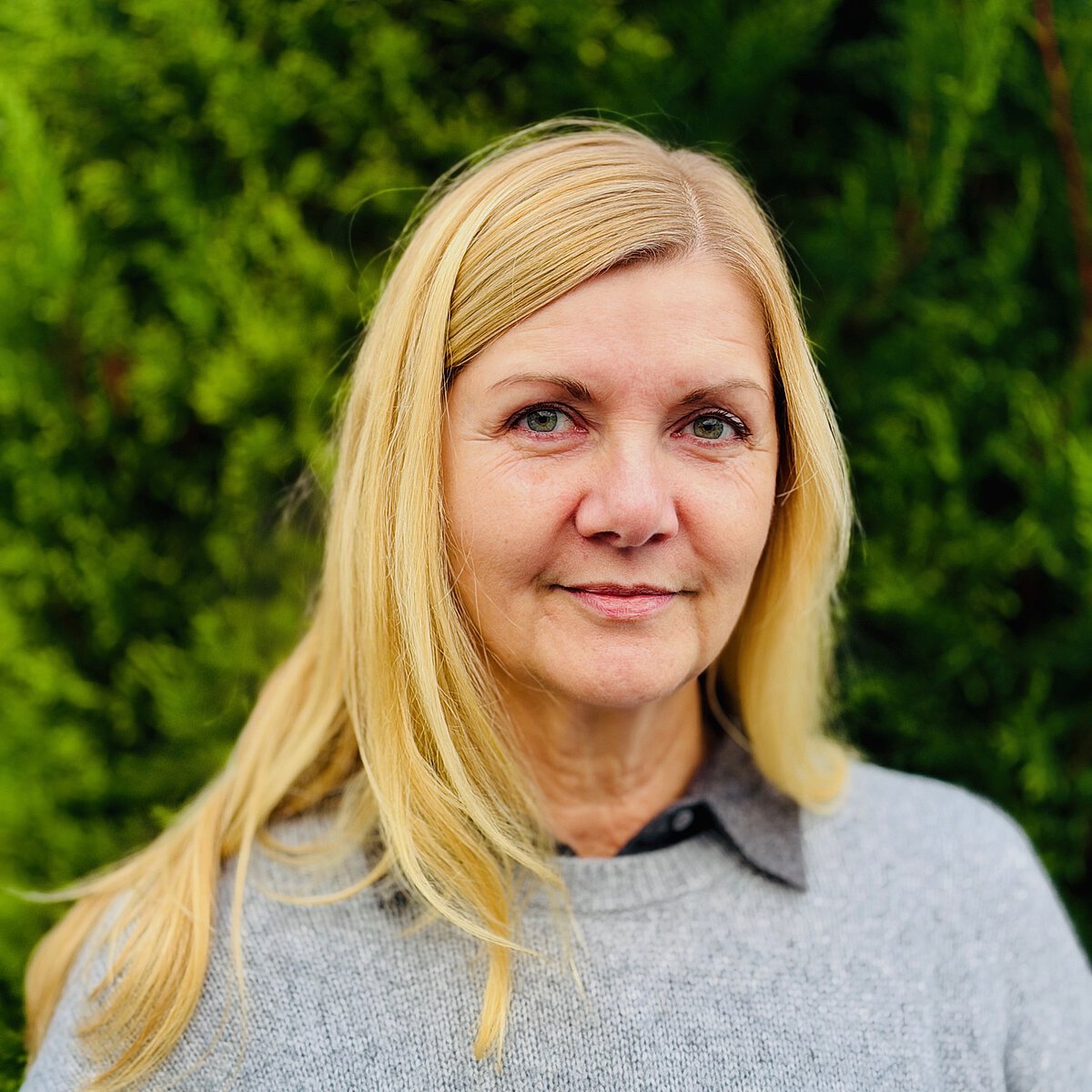 Einrichtungsleitung Freie berufsbildende Schule Jena Simone Flauger Portrait Schulleitung Freie berufsbildende Schule Jena Simone Flauger vor grünem, natürlichen Hintergrund