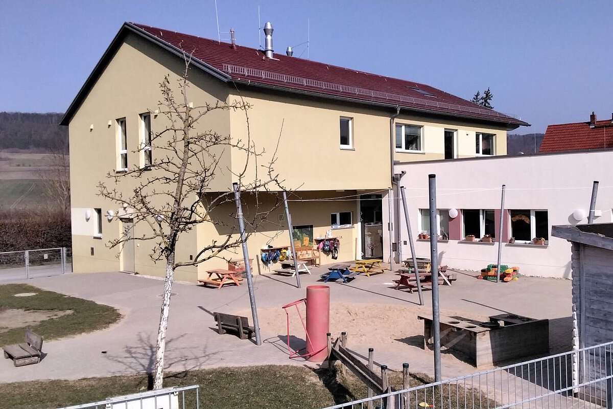 Gelbes Kita-Gebäude des Kindergartens Wogau mit Garten und Spielplatz
