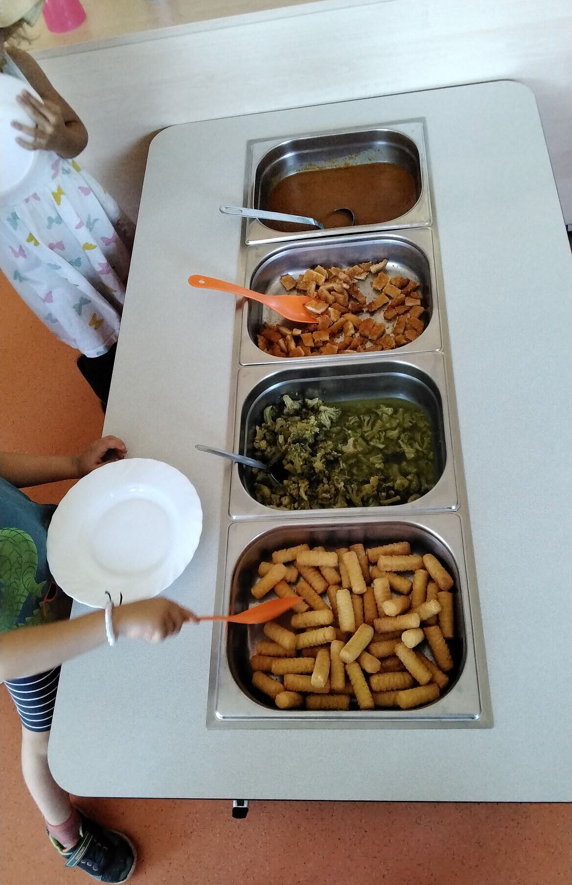 Kinder nehmen sich Essen vom Mittagsbuffet im Kindergarten Wogau