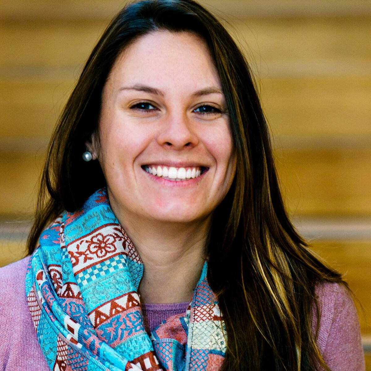 Portraitaufnahme von Einrichtungsleitung der Kindertagesstätte Kirschallee Juliane Haufe vor natürlichem beigem Hintergrund