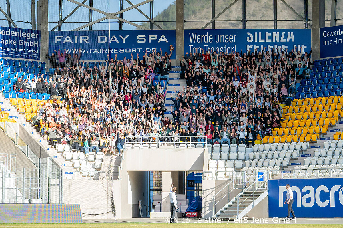 Mitarbeiter der TSA stehen unter Anzeigetafel der adhoc-Arena in Jena