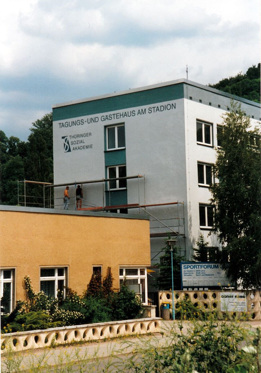 Historische Aufnahme des Tagungs- und Gästehauses am Stadion der Thüringer Sozialakademie, Gebäudeansicht mit Baugerüst und Beschriftung an der Fassade