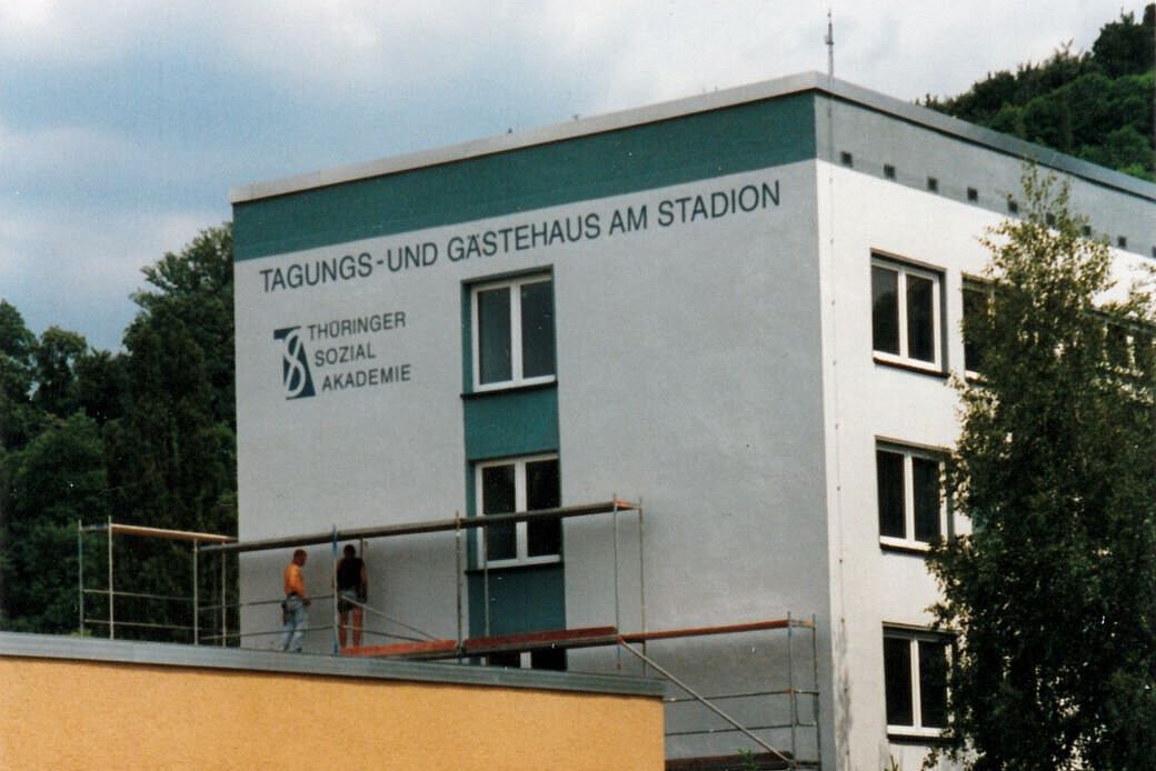 Akademiehotel Jena 1996 – Tagungs- und Gästehaus am Stadion Historische Aufnahme des Tagungs- und Gästehauses am Stadion der Thüringer Sozialakademie, Gebäudeansicht mit Baugerüst und Beschriftung an der Fassade
