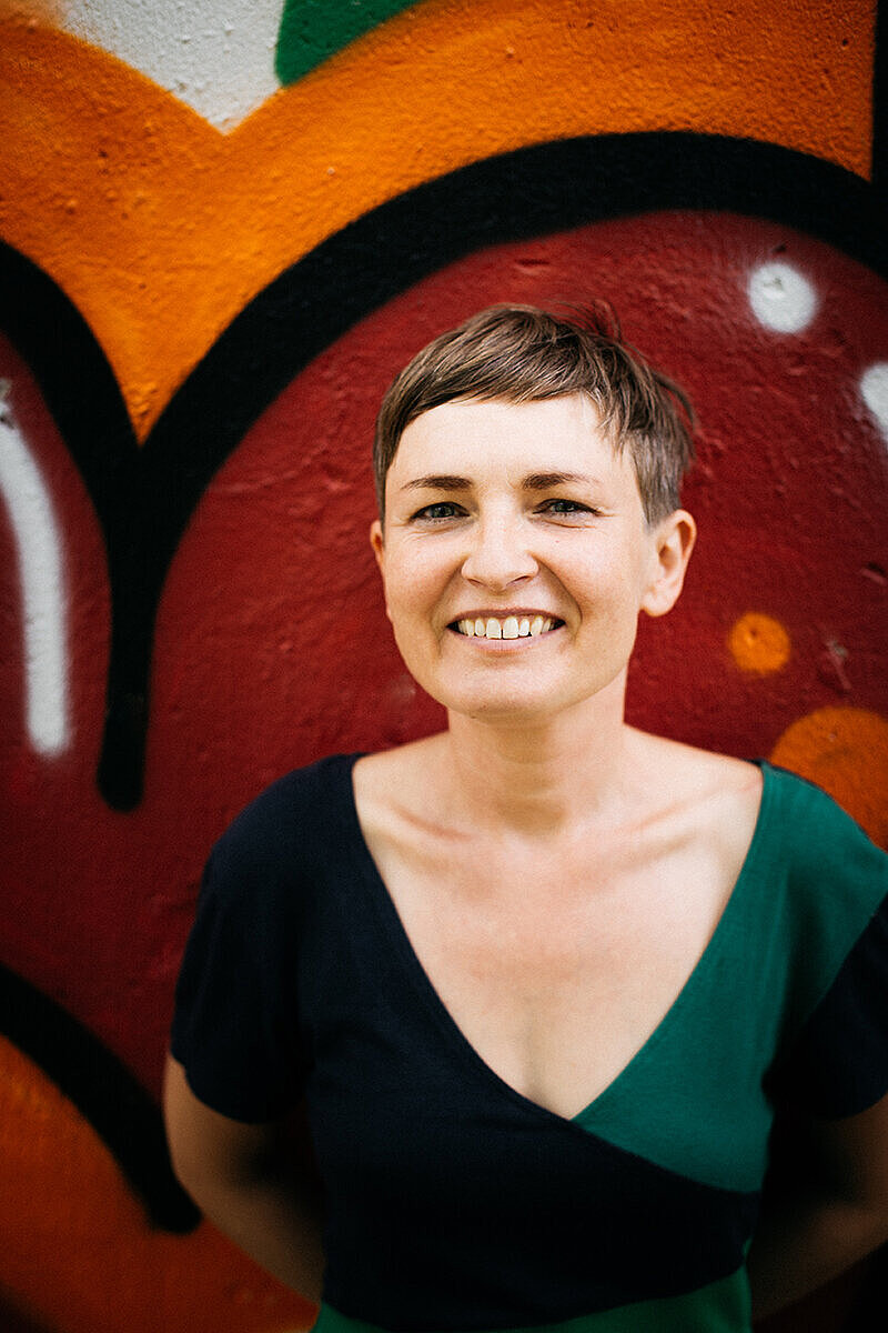 Sabine Dreßler vor buntem Hintergrund