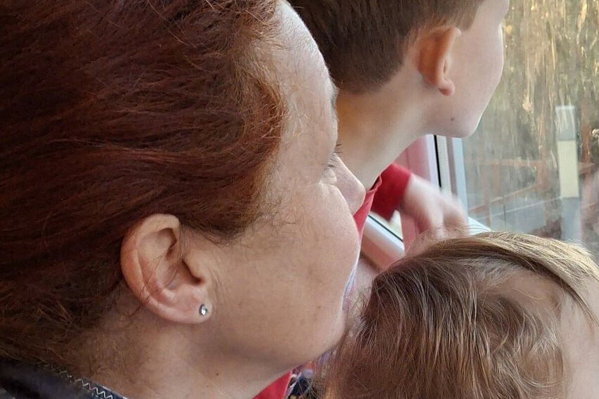 Pädagogische Fachkraft sitzt mit Kindern am Fenster und begleitet die Eingewöhnung in der Kita Bergfelderweg.