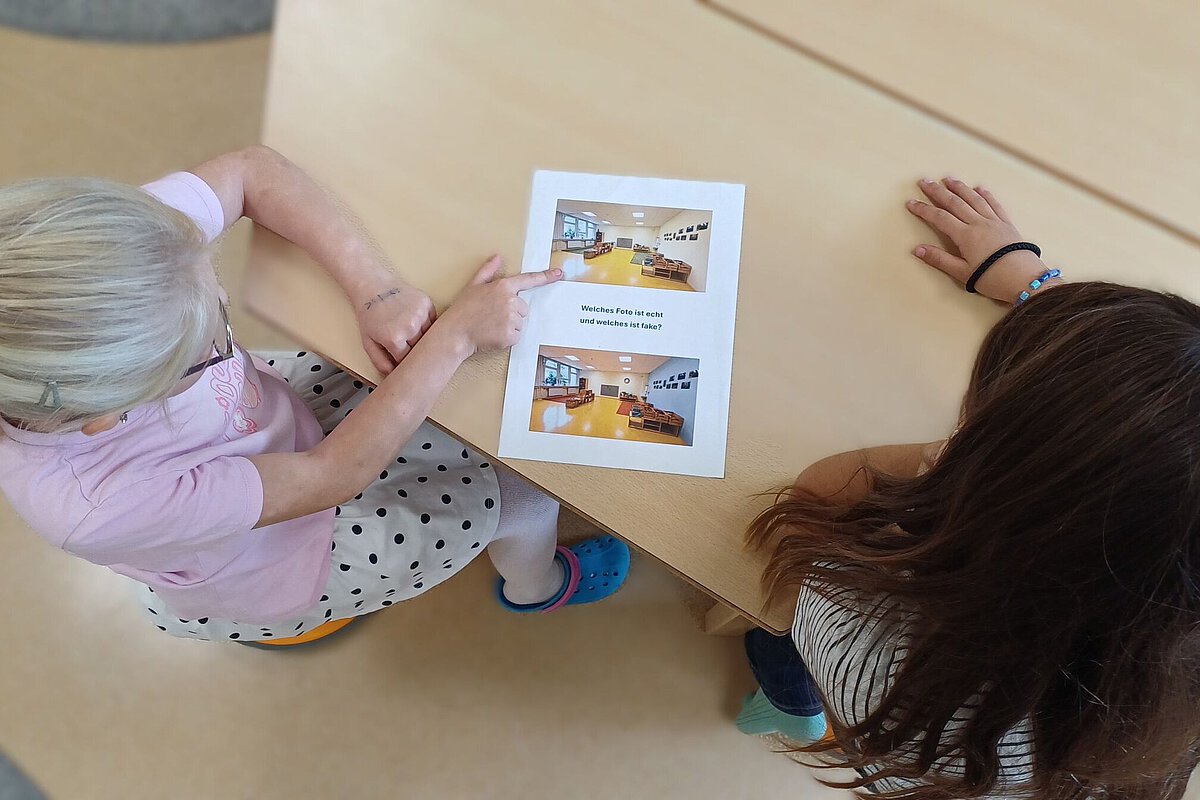 Kinder betrachten im Hort Hermsdorfein Arbeitsblatt und vergleichen echte mit KI-generierten Fotos, um den Umgang mit Künstlicher Intelligenz zu lernen.