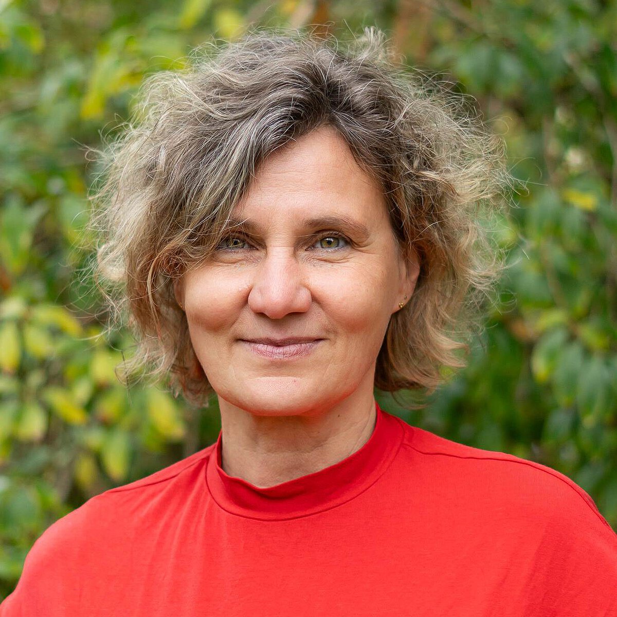 Einrichtungsleitung Susann Wolf des Montessori Kindergartens Tümplingstraße in Jena-Ost Porträt der Einrichtungsleitung Susann Wolf des Montessori Kindergartens Tümplingstraße vor grünem Hintergrund