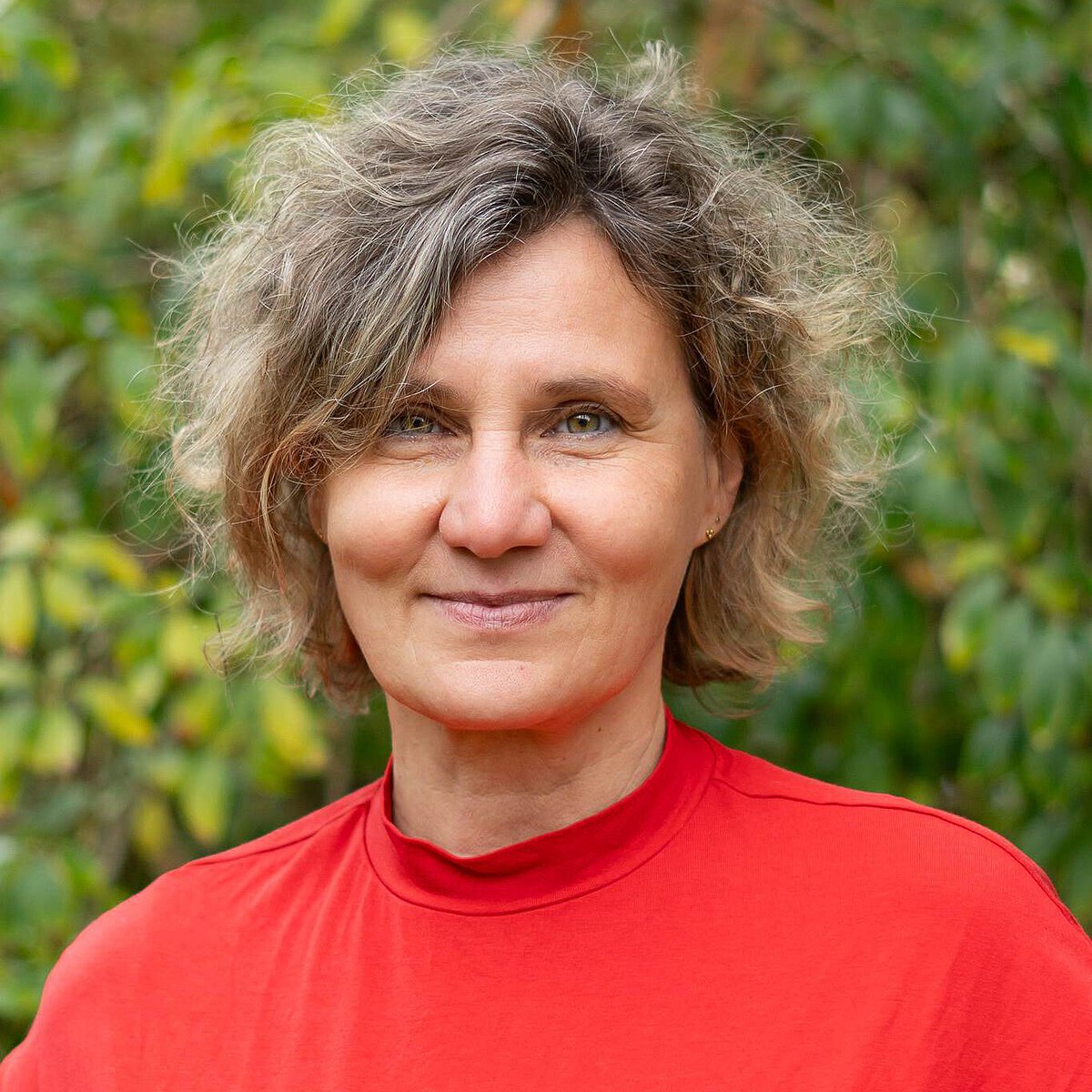 Einrichtungsleitung Susann Wolf des Montessori Kindergartens Tümplingstraße in Jena-Ost Porträt der Einrichtungsleitung Susann Wolf des Montessori Kindergartens Tümplingstraße vor grünem Hintergrund