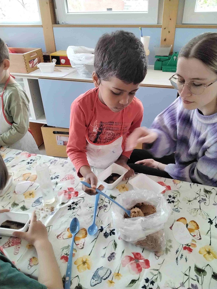 Erzieherin Sophia begleitet die Bastelaktion der Kinder und hilft