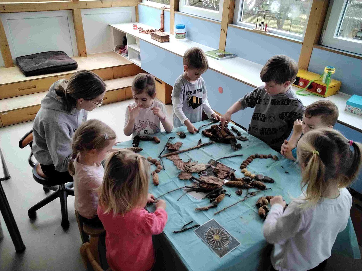 Erzieherin Sophia bastelt mit den Kindern mit Naturmaterialien
