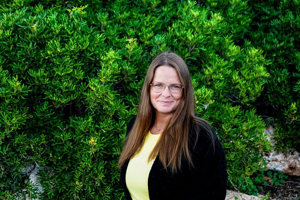 Portrait von Antje Richter vor grünem natürlichen Hintergrund im Freien