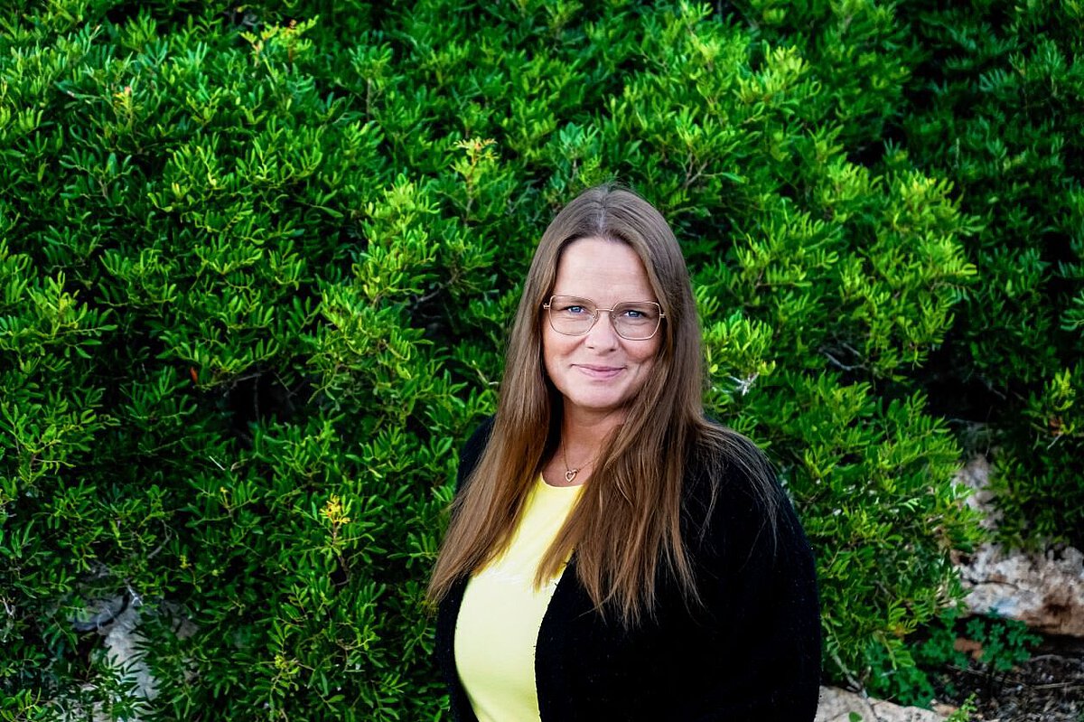 Portrait von Antje Richter vor grünem natürlichen Hintergrund im Freien