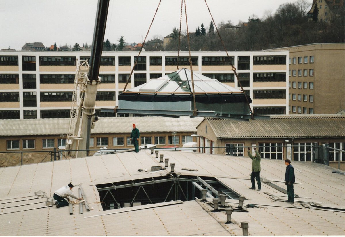 Umbauarbeiten auf dem Dach des Akademiehotels 1996 mit mehreren Personen und Kran beim Einsetzen eines Dachaufbaus