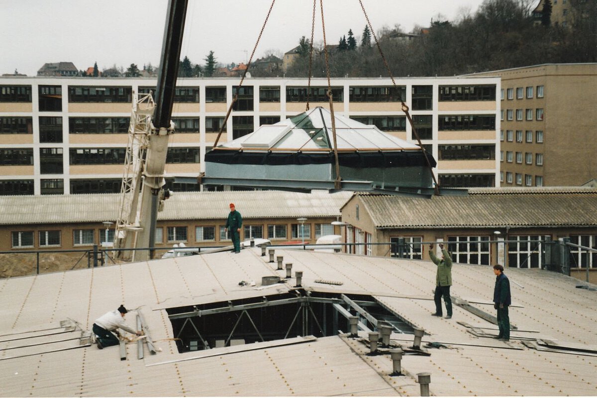 Akademiehotel Jena 1996 – Umbauphase Dacharbeiten Umbauarbeiten auf dem Dach des Akademiehotels 1996 mit mehreren Personen und Kran beim Einsetzen eines Dachaufbaus