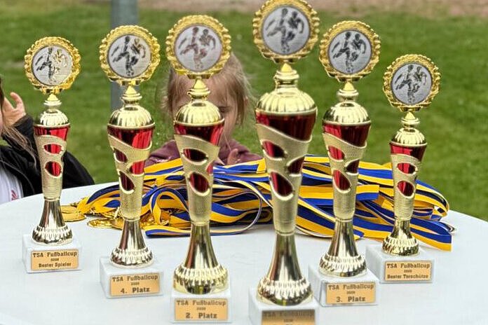 TSA Fußball-Cup 2026 in Vieselbach – Kita-Turnier stärkt Teamgeist Pokale und Medaillen des TSA Fußball-Cups 2026 auf einem Tisch auf dem Sportplatz in Vieselbach