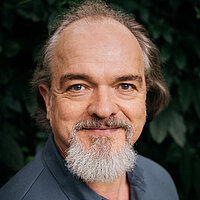 Lutz Knöschke FbS Dresden Portrait der Lehrkraft Lutz Knöschke vor einem grünen, natürlichen Hintergrund