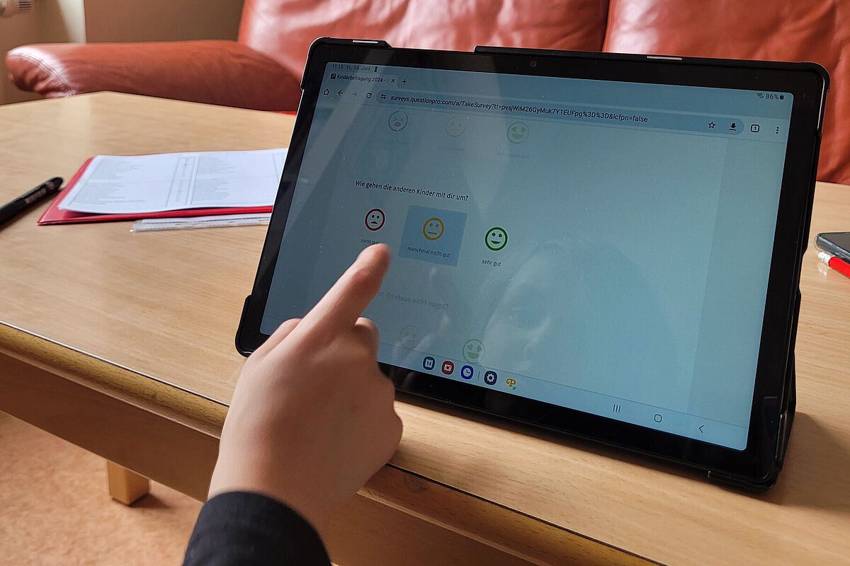 Kind in der Kita Lowi nimmt über Tablet an Meinungsumfrage teil