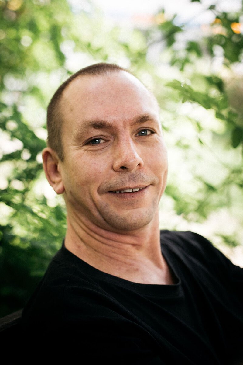 Portrait von Lehrkraft an der Freien berufsbildenden Schule Dresden Harald Köhler vor grünem natürlichen Hintergrund