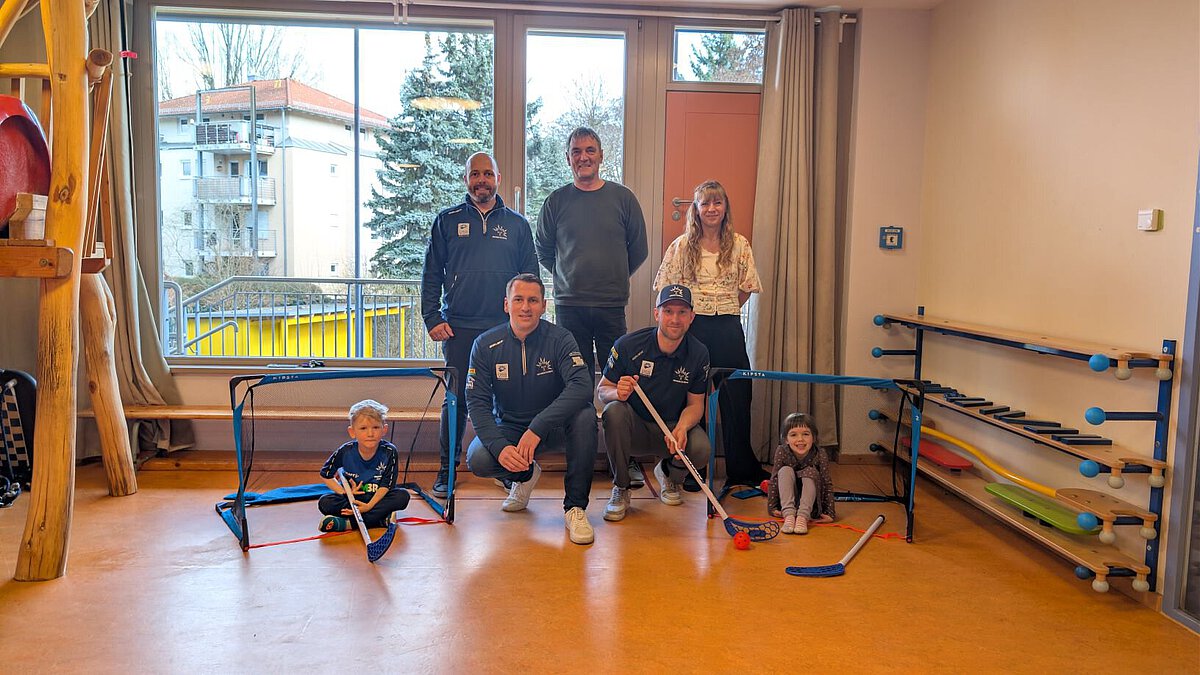 Kooperation der Eislöwen mit TSA in Kindertagesstätte Striesener Entdeckerland besiegelt, Kinder, Verein, Geschäftsleitung und Einrichtungsleitung lächeln in die Kamera