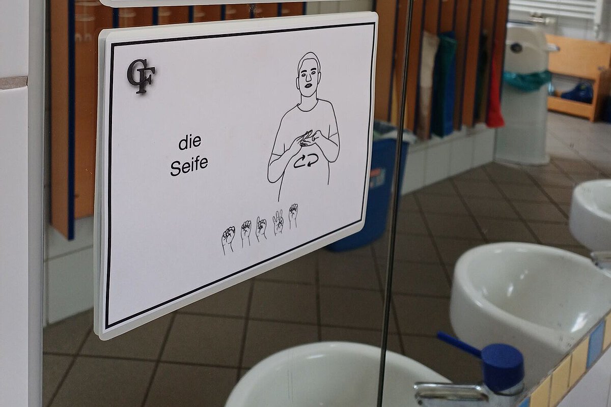 Gebärden-Bildkarten für „Spiegel“ und „Seife“ an einem Badezimmerspiegel im Waldkindergarten Ottendorf-Okrilla