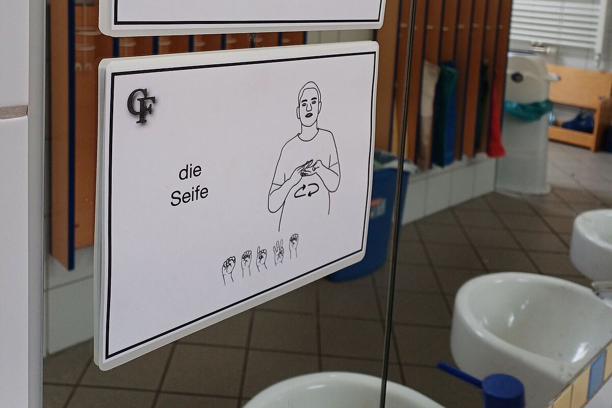 Gebärdenkarten unterstützen Orientierung im Kita-Alltag Gebärden-Bildkarten für „Spiegel“ und „Seife“ an einem Badezimmerspiegel im Waldkindergarten Ottendorf-Okrilla