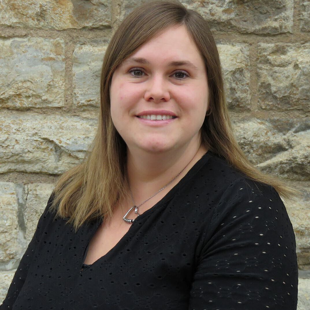 Porträtaufnahme vor Steinwand von Einrichtungsleitung Kindergarten Windischholzhausen Nancy Thümer Einrichtungsleitung Kindergarten Windischholzhausen Nancy Thümer im schwarzen Oberteil vor einer Steinmauer