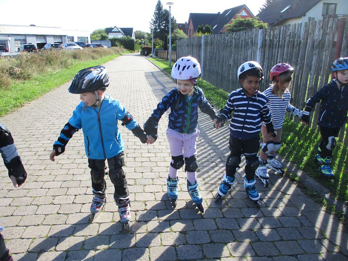 Bei unserem Inlinerkurs halten sich die Kinder an den Händen, während sie fahren