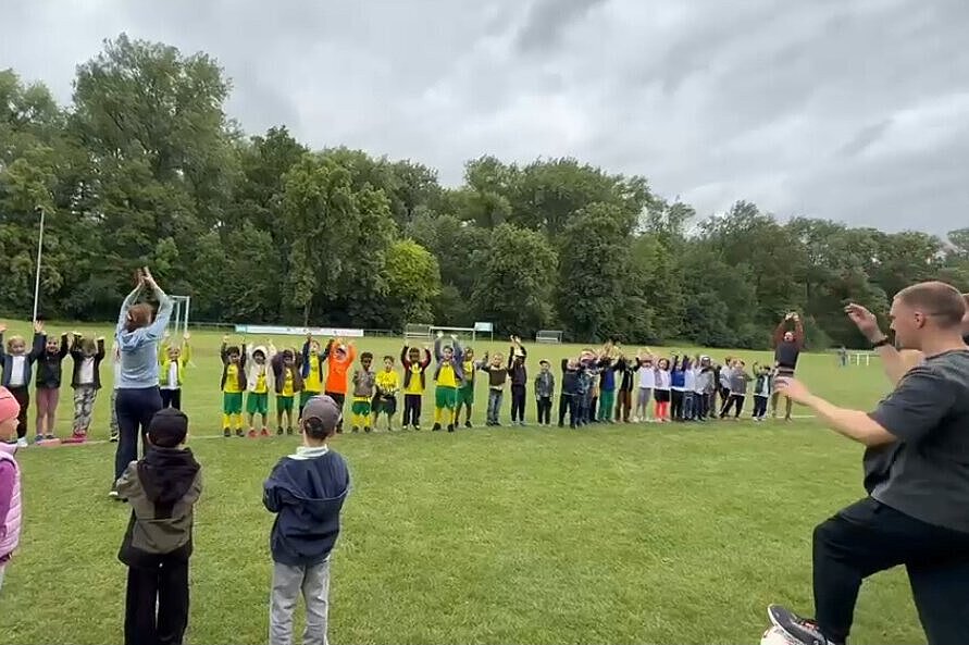 Aufwärmphase beim TSA Fußball Cup Kinder und Fachkräfte beim gemeinsamen Aufwärmen auf dem Sportplatz beim TSA Fußball-Cup in Vieselbach
