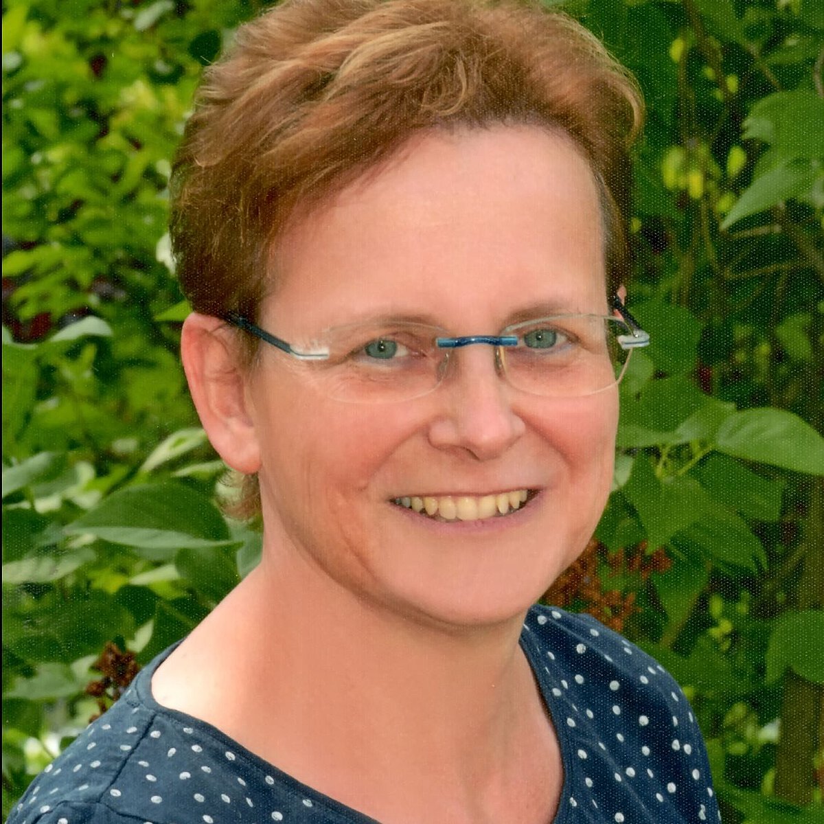 Einrichtungsleitung der Kindertagesstätte Bergfelderweg Cornelia Kamenka Portrait Einrichtungsleitung der Kindertagesstätte Bergfelderweg Cornelia Kamenka vor grünem natürlichen Hintergrund