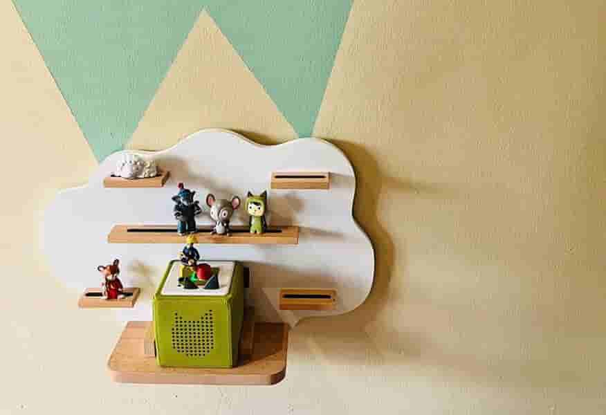 Toniebox im Wolkenregal – Hörspielstation mit Aufbewahrung für Toniefiguren im Kindergarten Grüne Toniebox in einem wolkenförmigen Wandregal im Kindergarten mit integrierter Aufbewahrung für Toniefiguren