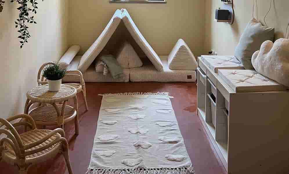 Ruheinsel im Kindergartenbereich – Gemütlicher Rückzugsort für Entspannung und Lesen Gemütliche Ruheinsel im Kindergartenbereich mit weichen Sitzkissen, Teppich, Tipi-Zelt und ruhiger Atmosphäre zum Entspannen