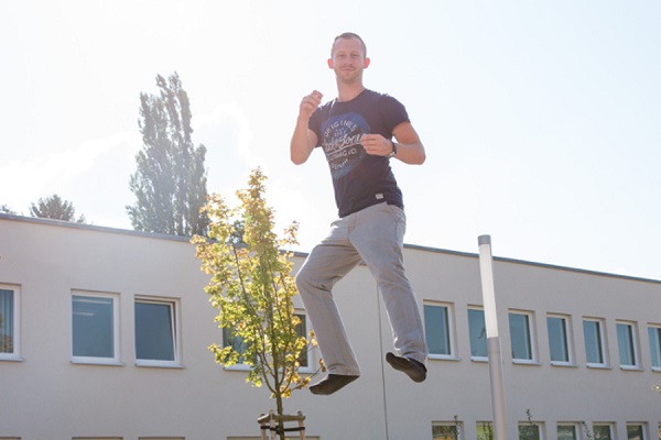 pädagogische Fachkraft des Kindergarten Sportforum in Jena eine pädagogische Fachkraft der Kita Sportforum springt auf dem Boden-Trampolin im Garten der Kita