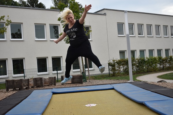 pädagogische Fachkraft des Kindergarten Sportforum in Jena eine pädagogische Fachkraft der Kita Sportforum springt auf dem Boden-Trampolin im Garten der Kita