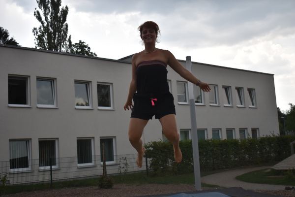 pädagogische Fachkraft des Kindergarten Sportforum in Jena eine pädagogische Fachkraft der Kita Sportforum springt auf dem Boden-Trampolin im Garten der Kita