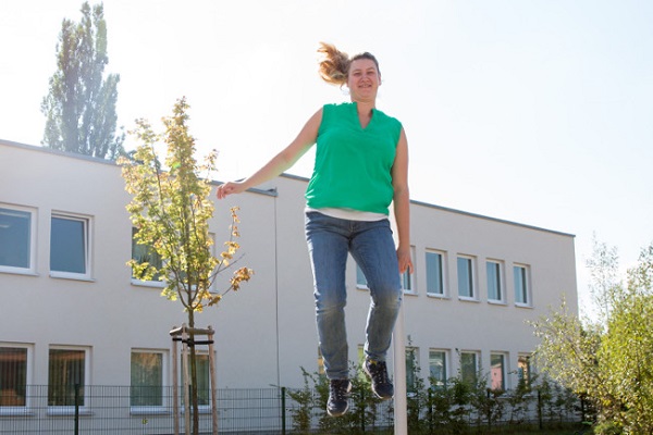pädagogische Fachkraft des Kindergarten Sportforum in Jena eine pädagogische Fachkraft der Kita Sportforum springt auf dem Boden-Trampolin im Garten der Kita