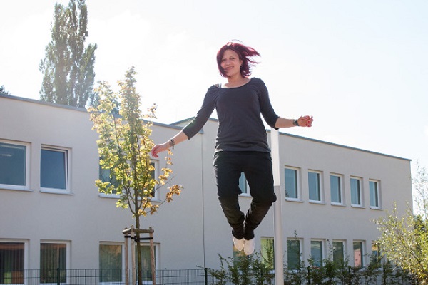 pädagogische Fachkraft des Kindergarten Sportforum in Jena eine pädagogische Fachkraft der Kita Sportforum springt auf dem Boden-Trampolin im Garten der Kita