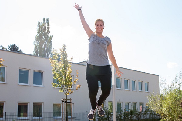 pädagogische Fachkraft des Kindergarten Sportforum in Jena eine pädagogische Fachkraft der Kita Sportforum springt auf dem Boden-Trampolin im Garten der Kita
