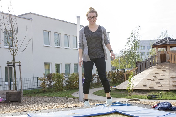 pädagoogische Fachkraft des Kindergarten Sportforum in Jena eine pädagogische Fachkraft der Kita Sportforum springt auf dem Boden-Trampolin im Garten der Kita